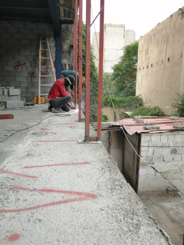 کارگران در حال جوشکاری اتصالات والپست برای مقاوم‌سازی دیوار