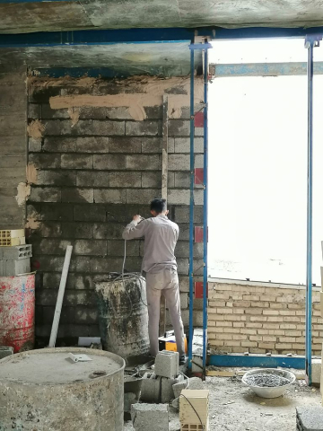 کارگران در حال تکمیل دیوار های داخلی ساختمانی که برای مقاوم سازی آن از والپست استفاده شده است