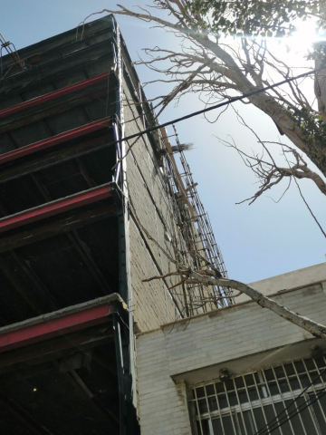 نمای بیرونی ساختمان در حال ساخت که در آن از والپست در نما و دیوارهای غیرباربر استفاده شده است.