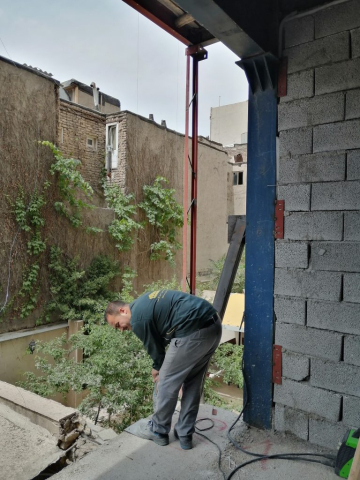 اتصال دیوار غیرباربر به اسکلت توسط کارگران مجرب