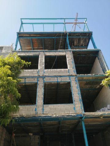 تصویری از نمای ساختمان در حال ساخت که در حال نصب والپست در نما و دیوارهای غیرباربر است.